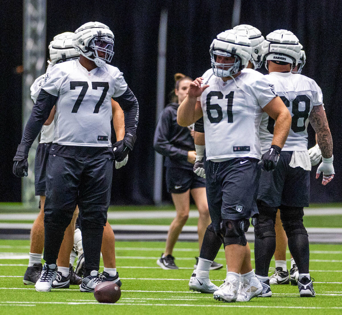 Raiders offensive tackle Thayer Munford Jr. (77) talks with guard Jordan Meredith (61) during ...