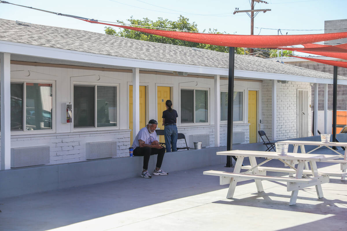 People sit outside of rooms at the grand opening of the Navigation Center, a location where unh ...