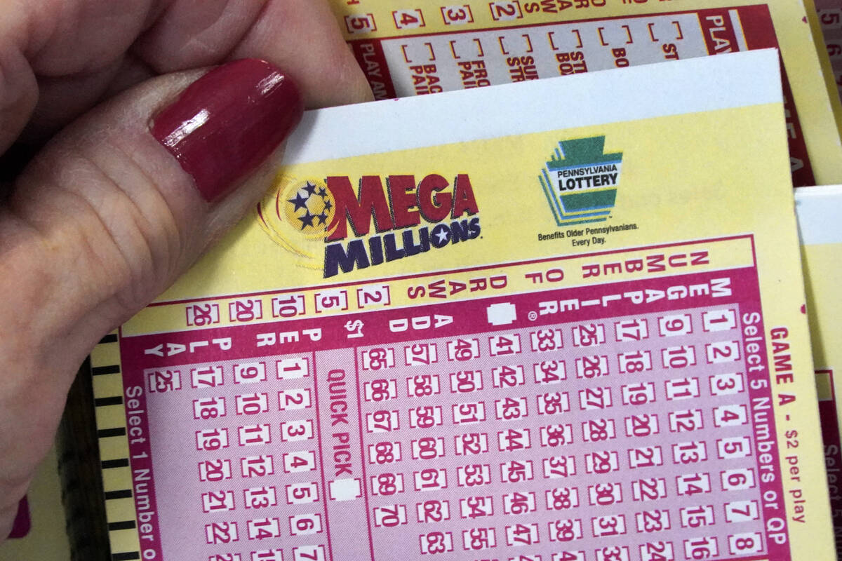 A Mega Millions wagering slip is held in Cranberry Township, Pa., Jan. 12, 2023. (AP Photo/Gene ...
