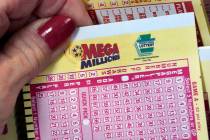 A Mega Millions wagering slip is held in Cranberry Township, Pa., Jan. 12, 2023. (AP Photo/Gene ...