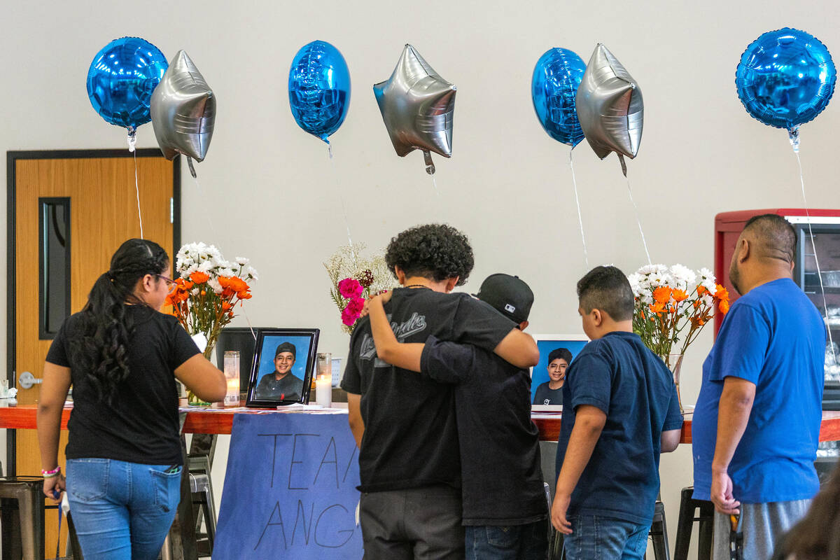 Mourners gather at a memorial table of items from Angel Naranjo during a food and drink fundrai ...