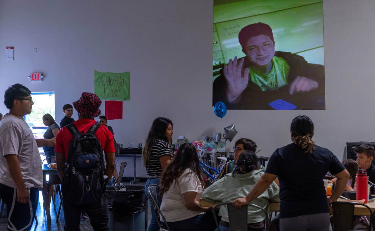 A slideshow of Angel Naranjo plays on the wall during a food and drink fundraiser for the famil ...