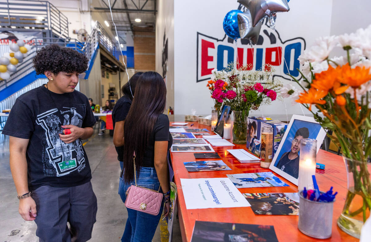 Friends stop at a memorial table of items from Angel Naranjo during a food and drink fundraiser ...