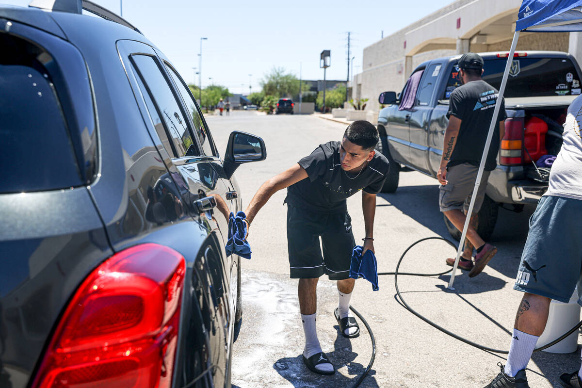 Gilbert Gamino wipes down a car at a car wash to raise money for the family of Angel Naranjo, w ...