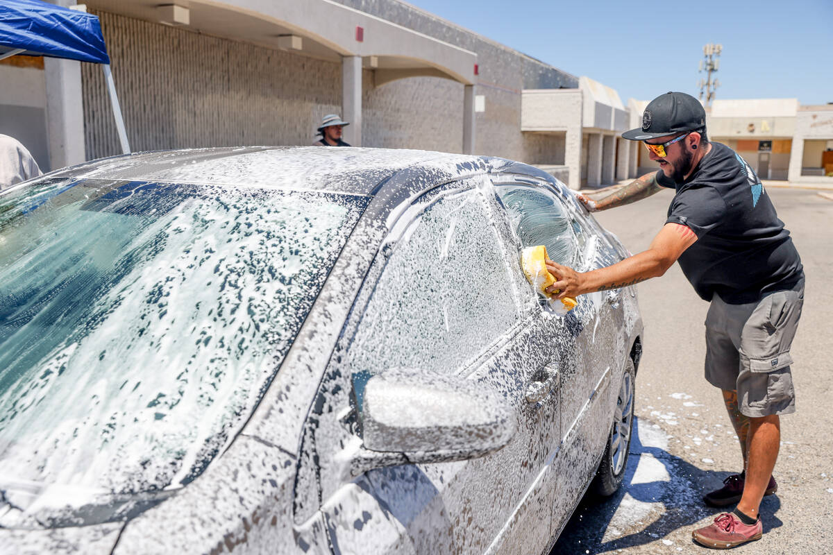 Steven Nava washes a car to raise money for the family of Angel Naranjo, who was killed from a ...
