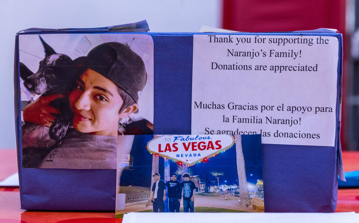 A box soliciting handwritten notes and donations sits atop a memorial table of items from Angel ...