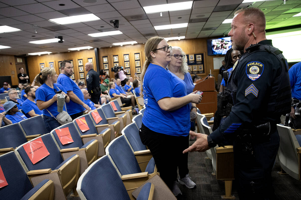 A police officer asks Clark County Education Association teachers union members to leave a scho ...