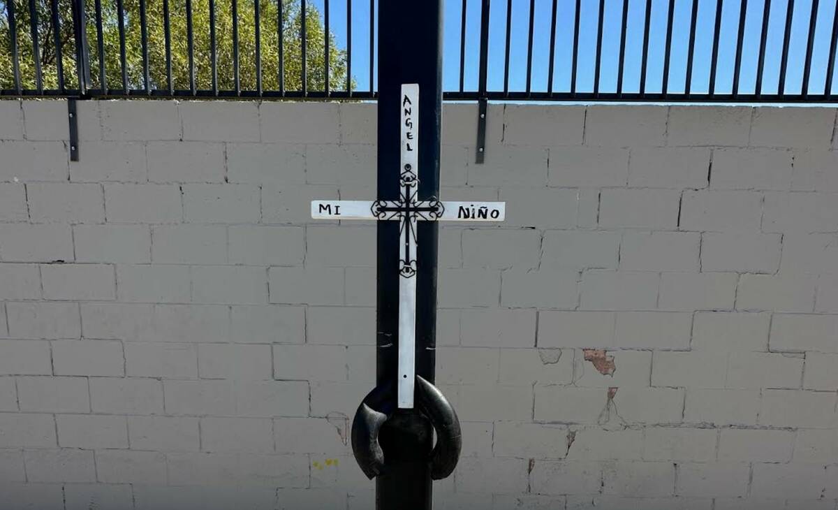A white cross has been attached to the light post near the spot where Angel Naranjo, 16, was ki ...