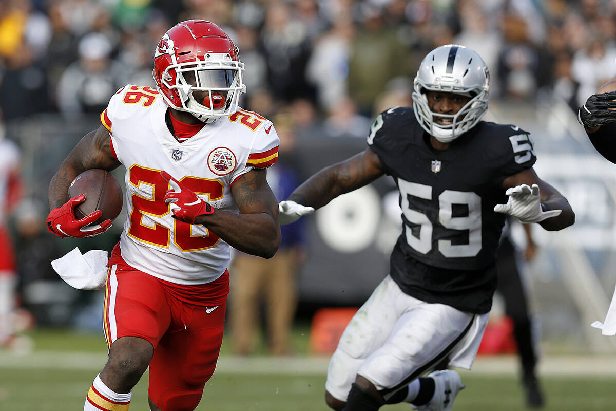 Kansas City Chiefs running back Damien Williams (26) runs in front of Oakland Raiders linebacke ...