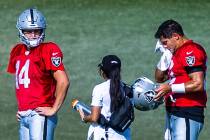 Raiders quarterback Jimmy Garoppolo (10) wipes his face as quarterback Chase Garbers (14) durin ...