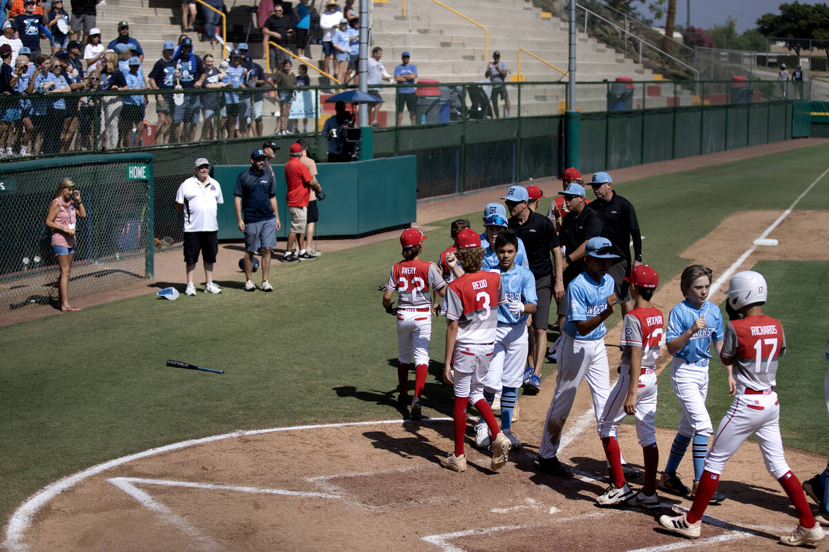 Henderson and Utah bump fists after the Little League West Regional final baseball game at Al H ...