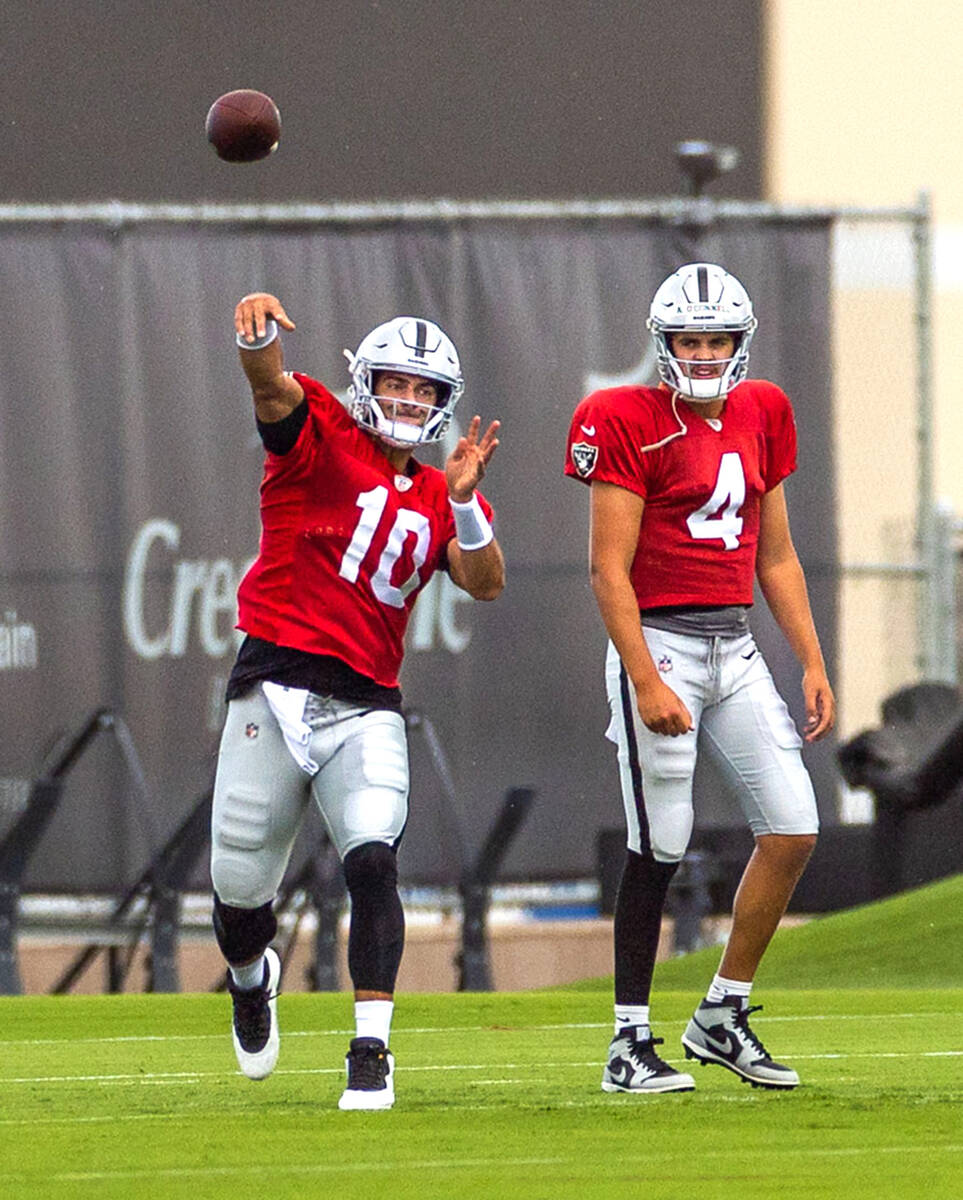 Raiders quarterback Jimmy Garoppolo (10) throws as quarterback Aidan O'Connell (4) looks on dur ...