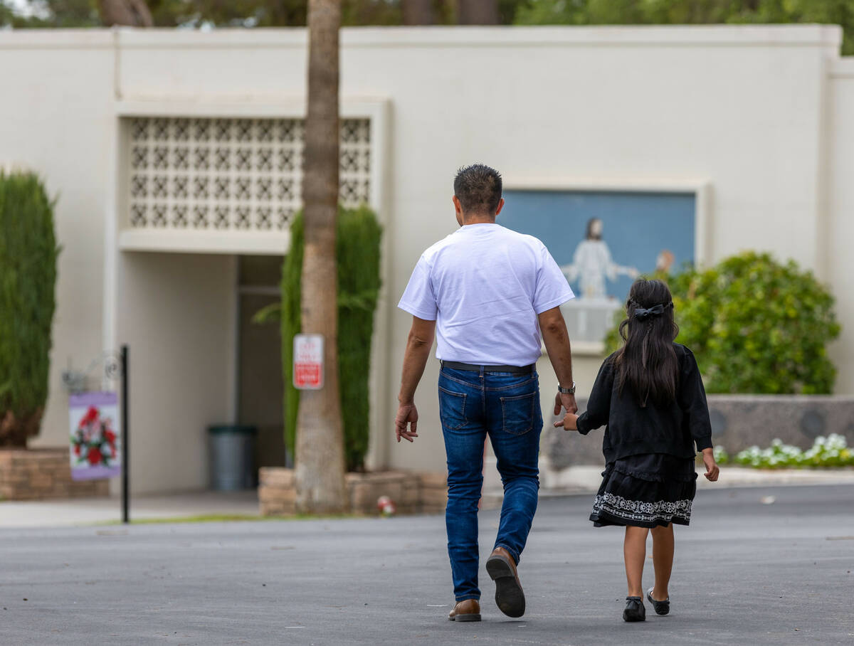 Rudolfo Naranjo walks with his daughter to show her where his son Angel is to be buried before ...