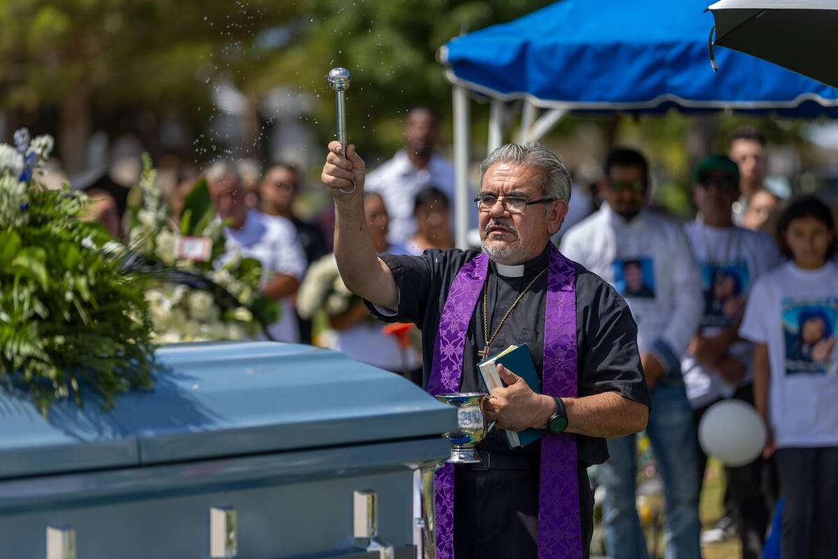 Rev. Jorge Hernandez sprinkles holy water on the casket of Angel Naranjo during funeral servic ...