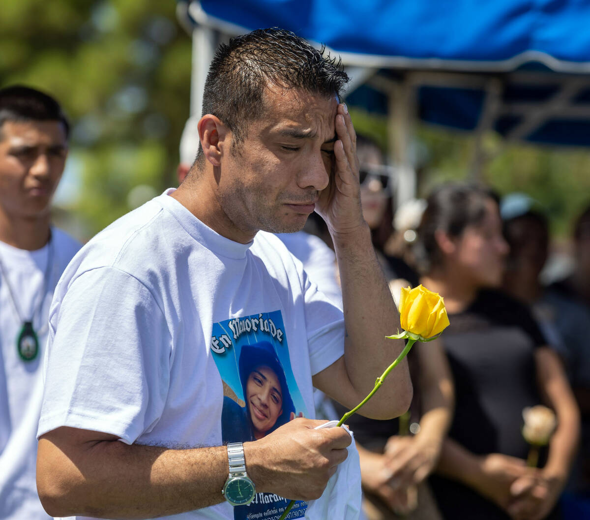 Rudolfo Naranjo weeps while watching as the casket of his on Angel is lowered into the ground d ...
