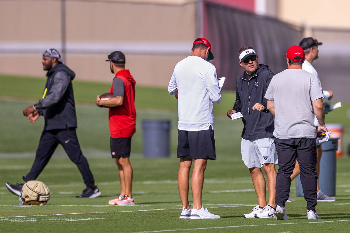 Raiders head coach Josh McDaniels talks with San Francisco 49ers head coach Kyle Shanahan, left ...