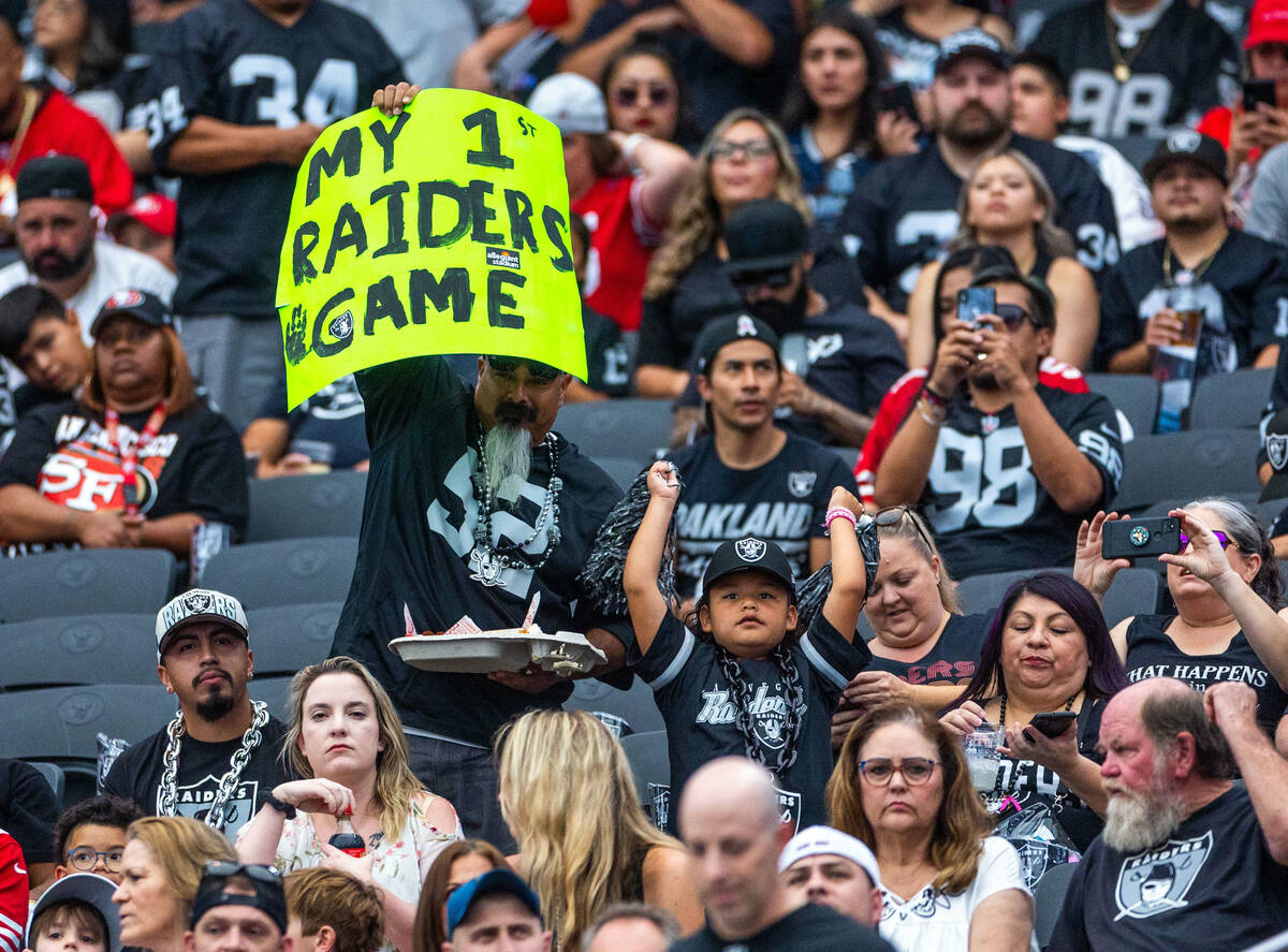 Fans hold a sign in the stands during the half in a first preseason NFL game with the Raiders a ...