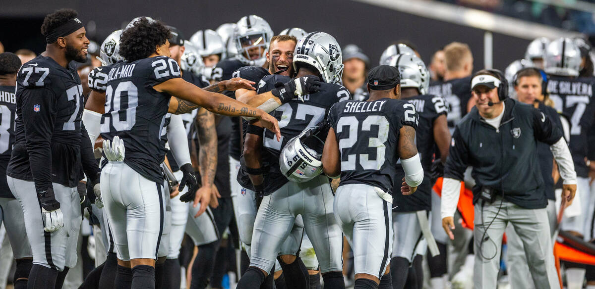 Raiders cornerback Sam Webb (27) is congratulated by teammates on his interception on the sidel ...