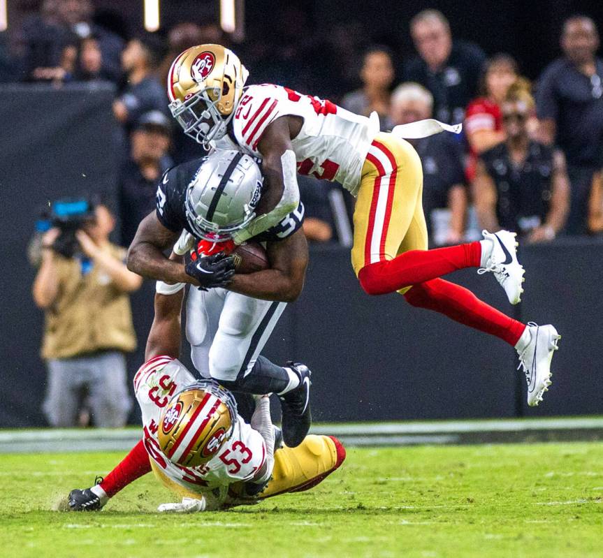 Raiders running back Austin Walter (32) is tacked by San Francisco 49ers linebacker Dee Winters ...
