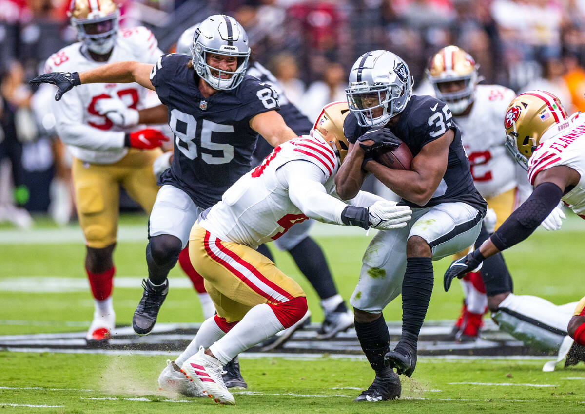 Raiders running back Zamir White (35) absorbs a hit by San Francisco 49ers linebacker Marcelino ...