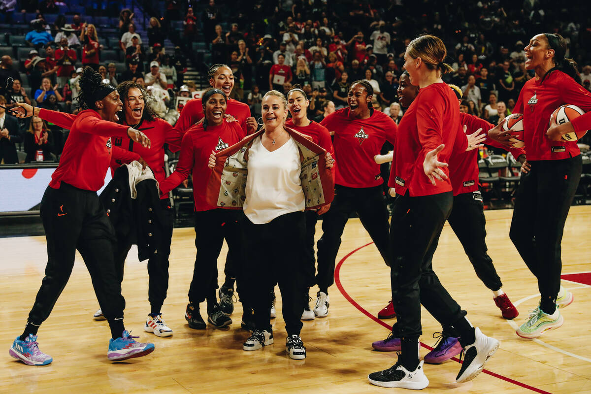 Aces head basketball coach Becky Hammon, center, shows off her Naismith Basketball Hall of Fam ...
