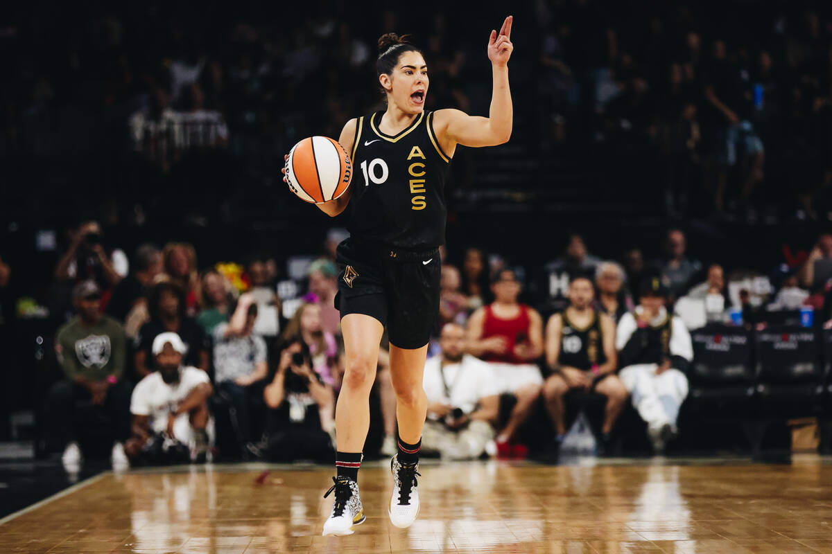 Aces guard Kelsey Plum yells to a teammate while traveling down the court with the ball during ...