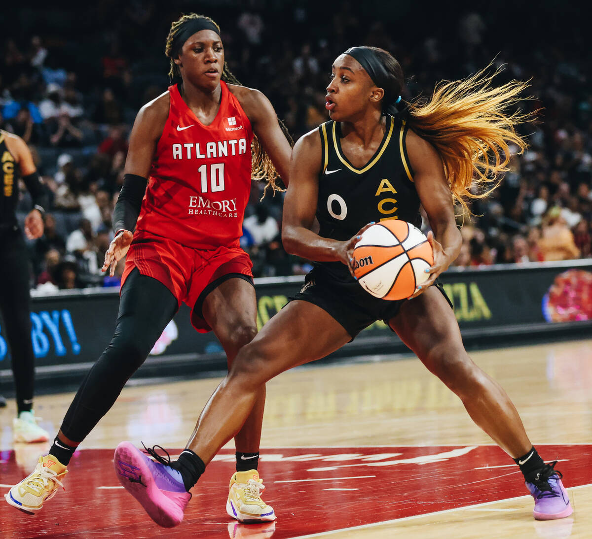 Aces guard Jackie Young (0) moves the ball past Atlanta Dream guard Rhyne Howard (10) during a ...