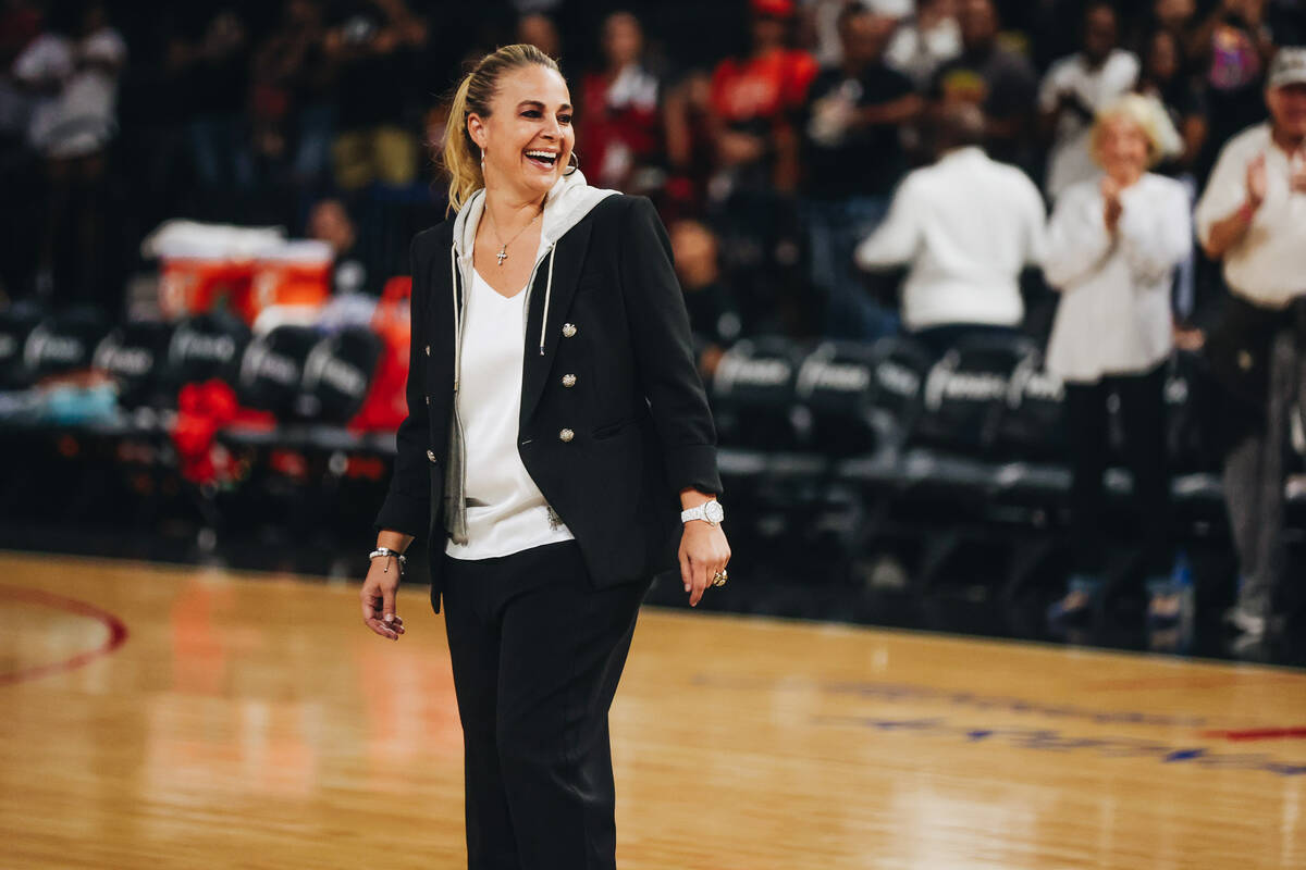 Aces head basketball coach Becky Hammon laughs as she walks onto the court before coaching her ...