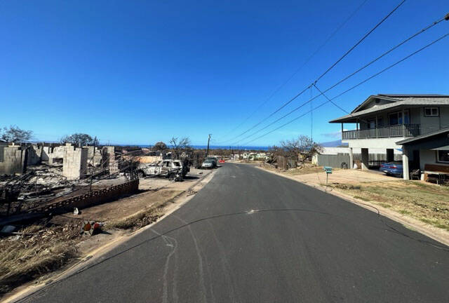 The building on the right appears to have escaped the wildfire in Maui, but not ones on the lef ...