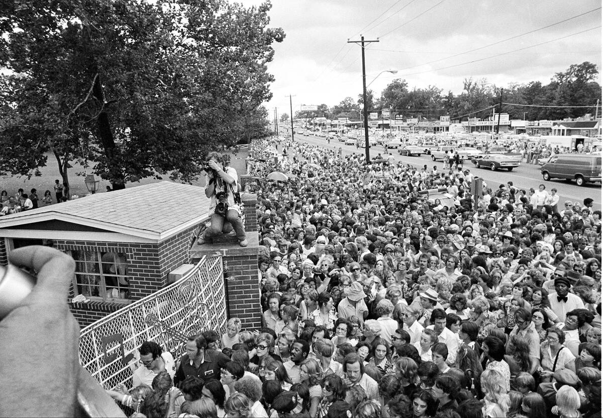 Hundreds of people wait outside the late Elvis Presley's Graceland mansion before the gates are ...