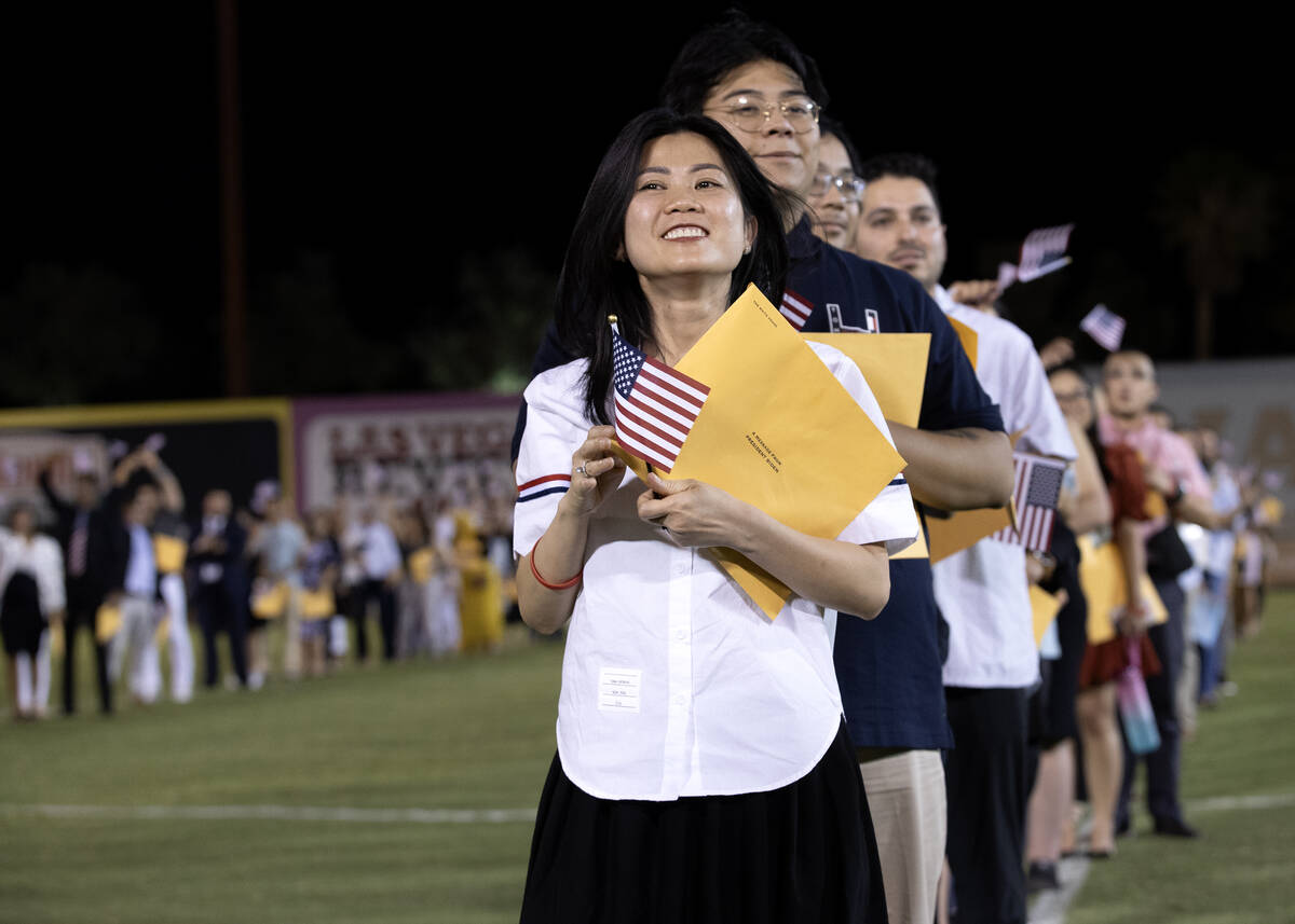 New U.S citizens smile during their naturalization ceremony during halftime of a Las Vegas Ligh ...