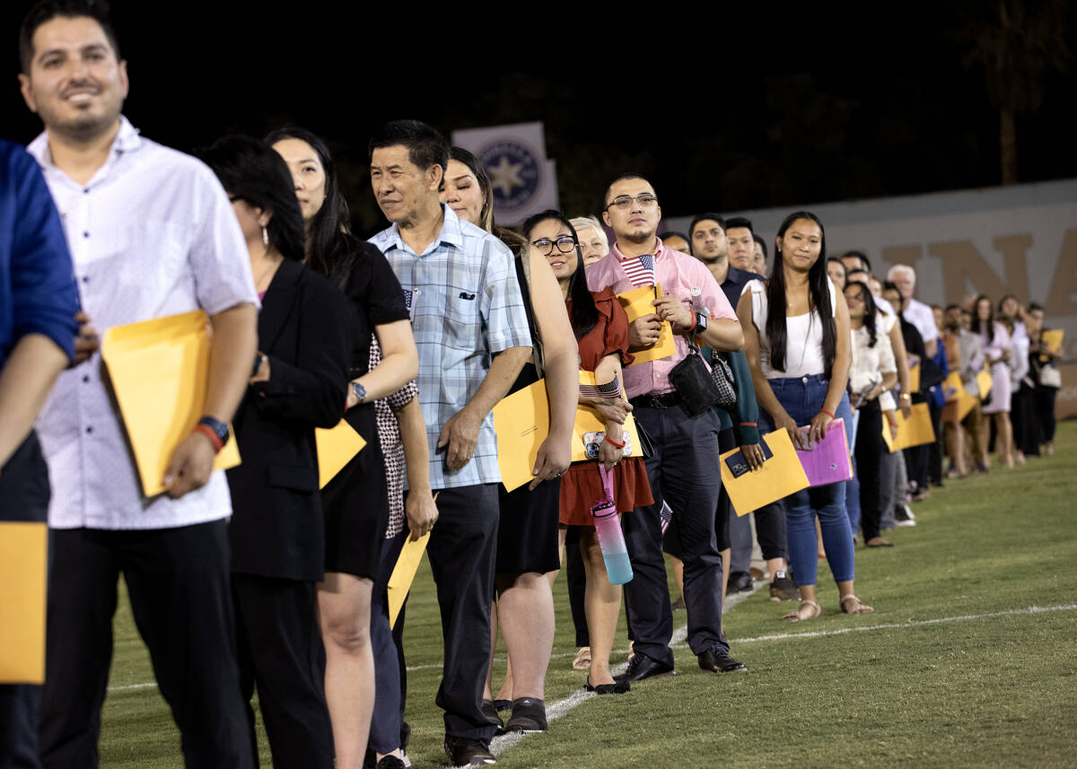 New U.S citizens look into the crowd during their naturalization ceremony during halftime of a ...
