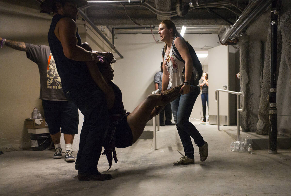 People assist a wounded woman at the Tropicana during an active shooter situation on the Las Ve ...