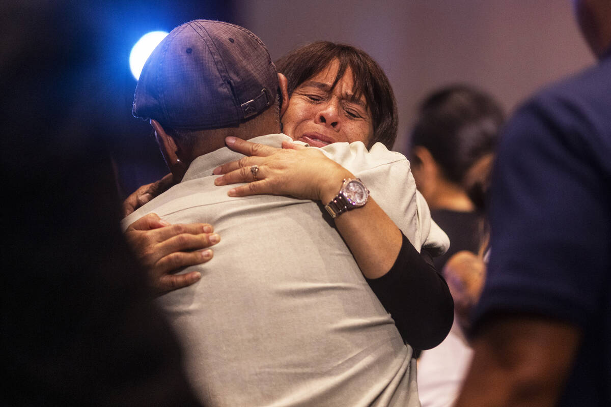 Attendees embrace during a church service at King's Cathedral in Kahului on the island of Maui, ...