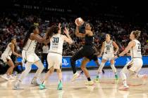 The New York Liberty close in on Las Vegas Aces forward A'ja Wilson (22) while she shoots durin ...