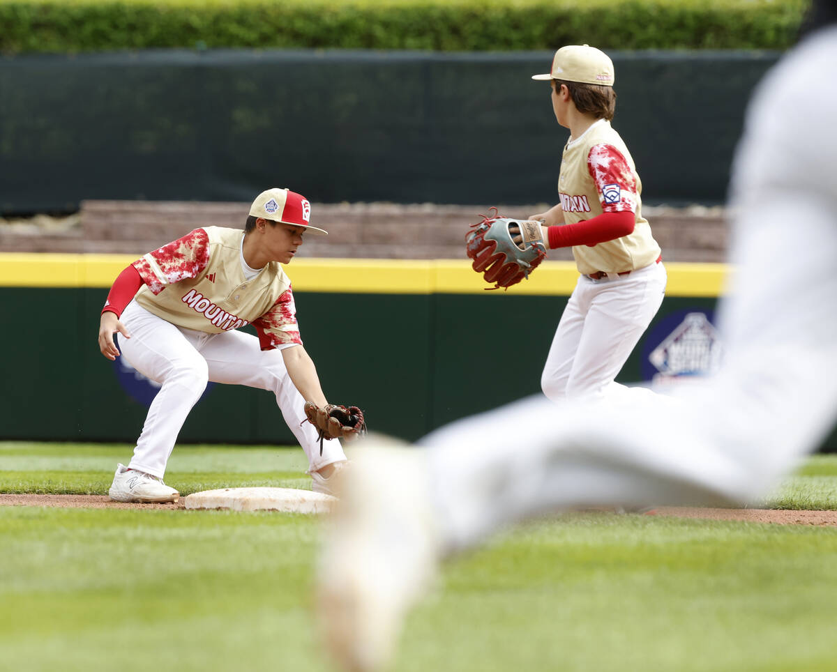 The Henderson All-Stars shortstop David Edwards, left, is unable to stop the ball hit by Rhode ...