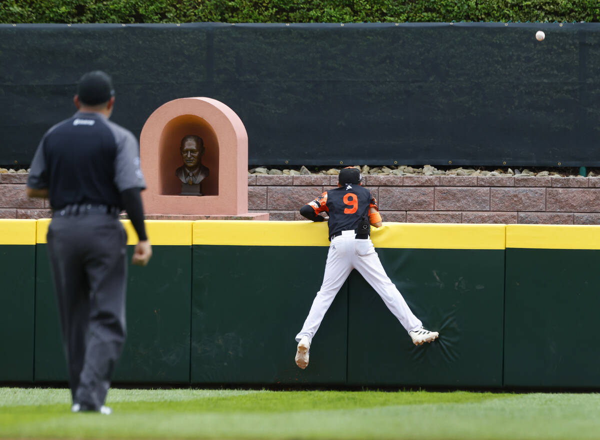 Rhod Island's centerfielder Gavin Gibree (9) climbs the fence but can only watch as the solo ho ...