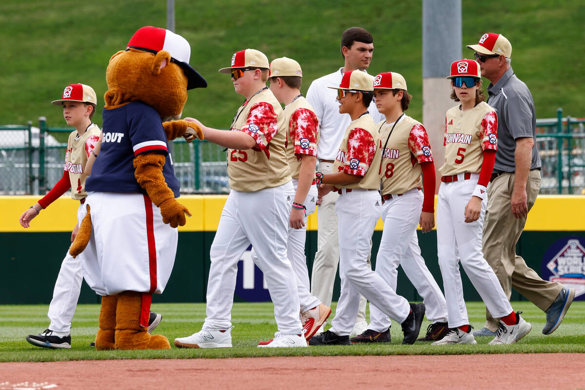The Henderson All-Stars are greeted by Dugout, the official mascot of Little League baseball, a ...