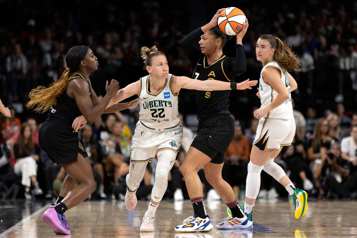 Las Vegas Aces forward Alysha Clark (7) attempts to pass to guard Jackie Young, left, while New ...