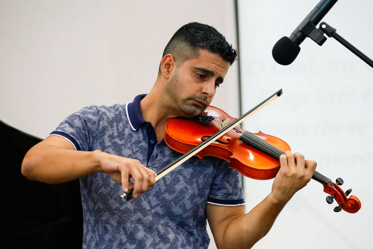 Yasher Agah plays the violin at a devotional for the Hawaiian fire victims held at the Baha'i C ...
