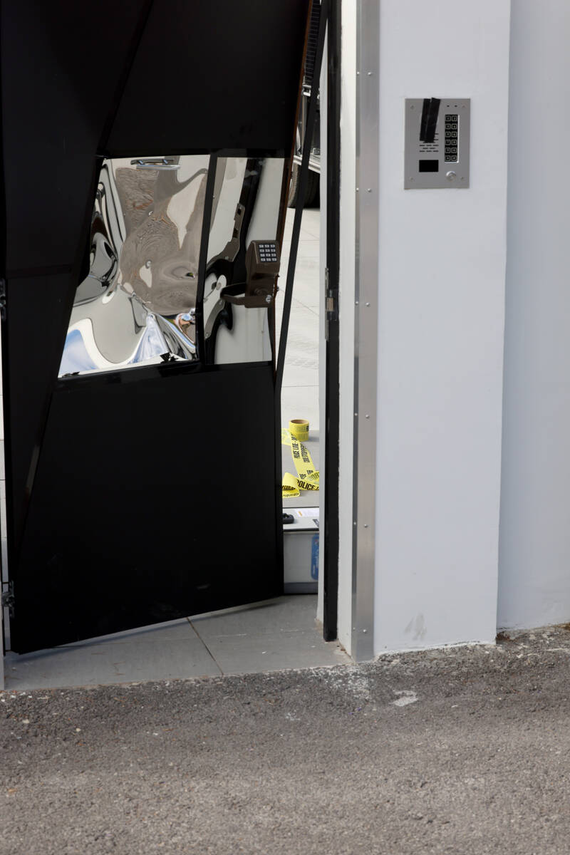 Crime scene tape and a damaged door are seen at a home on the corner of West La Madre Way and C ...
