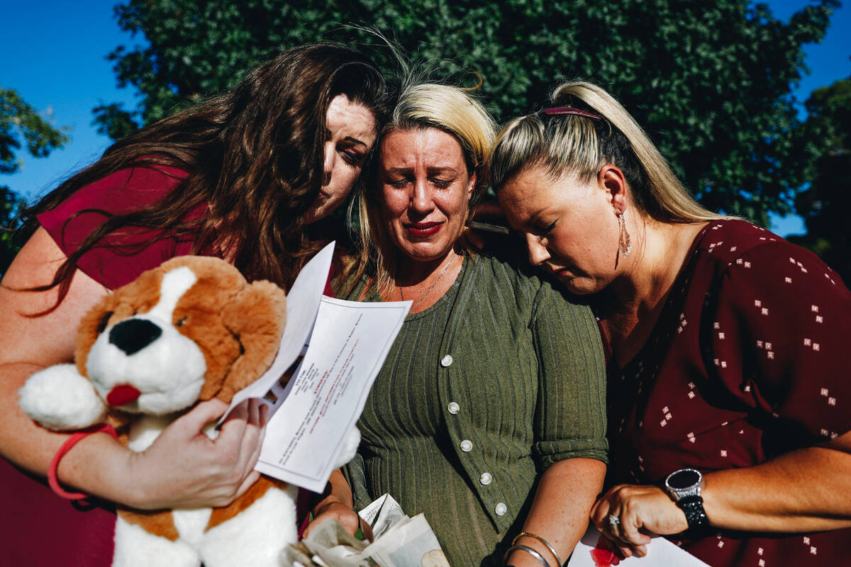 Danielle Wingett, middle, cries as Nathalie Walker, left, and Velvette Williams comfort her whi ...