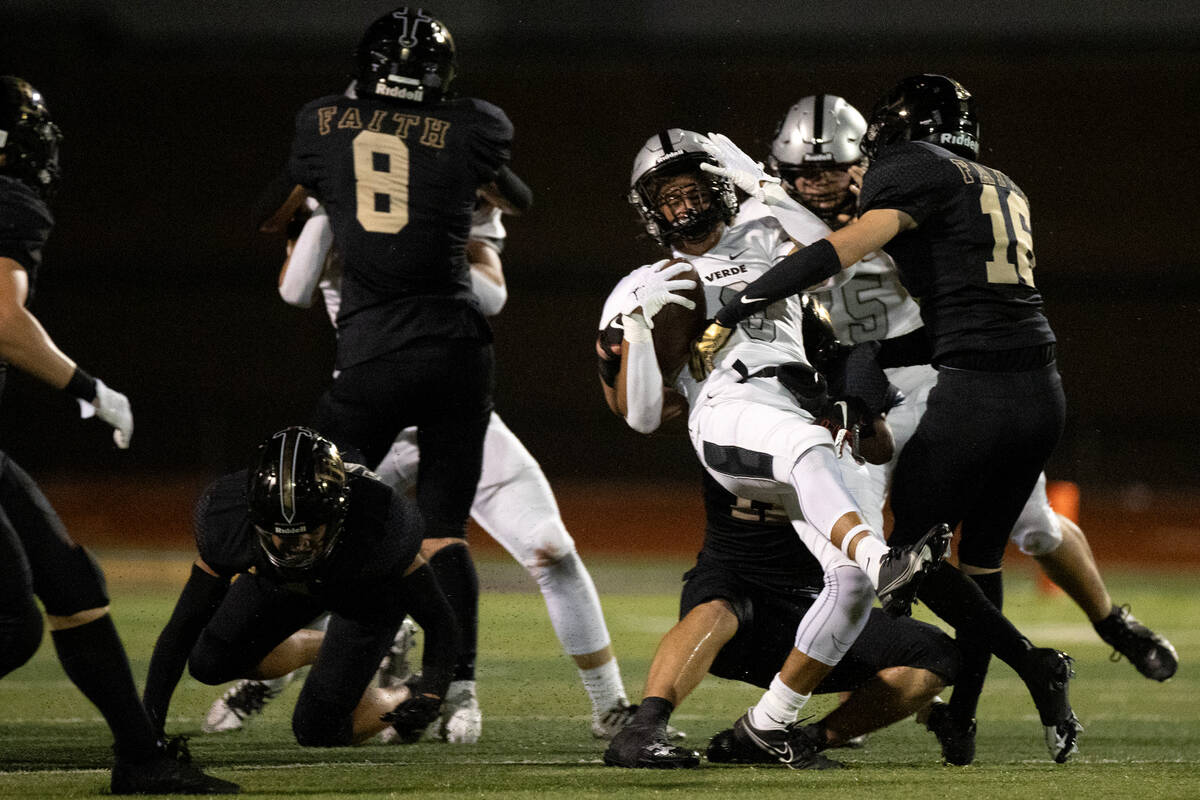 Palo Verde’s Cedric Cade Jr., center, is taken down by Faith Lutheran’s Matthew M ...