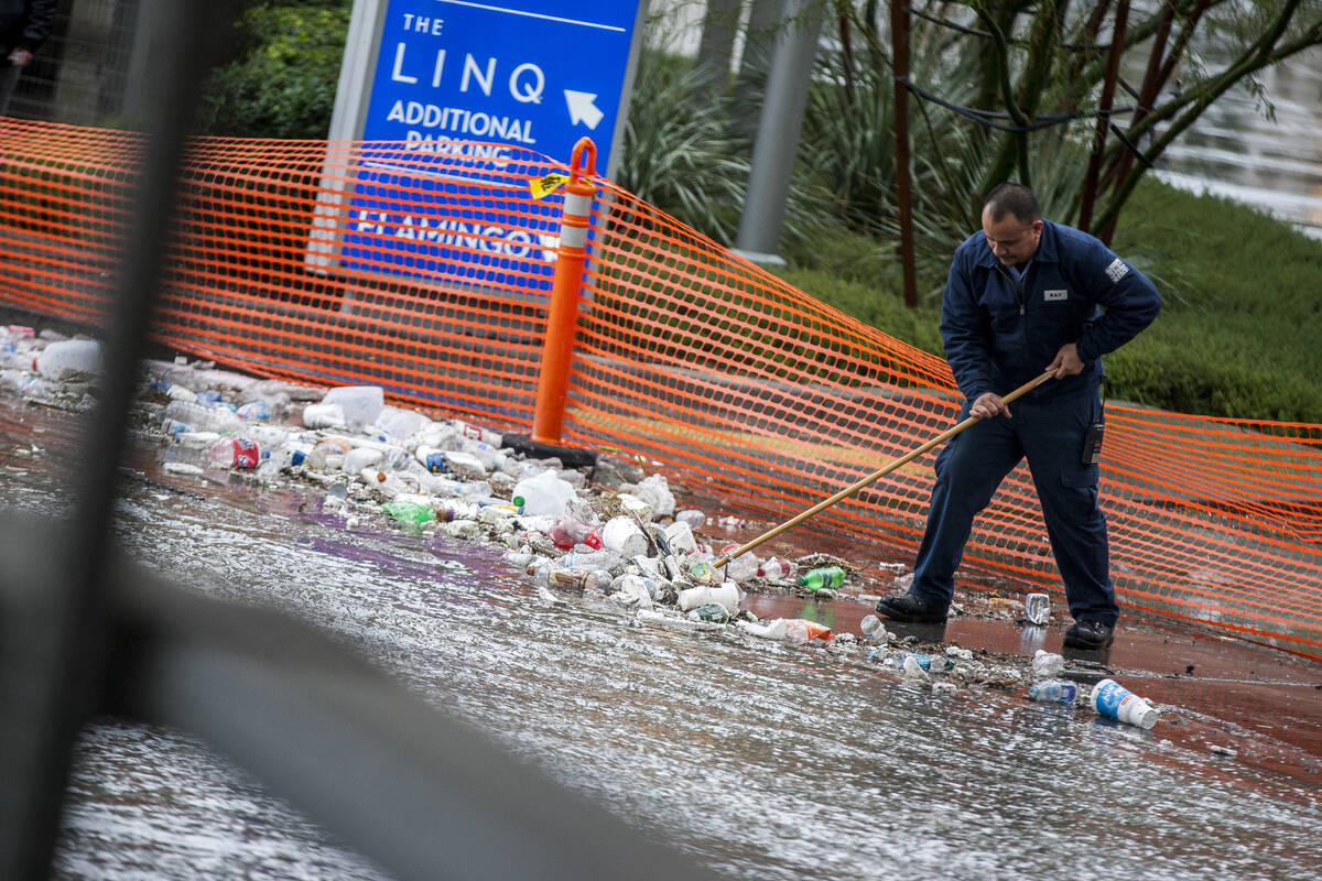 A Linq maintenance worker clears debris near a flood channel in Las Vegas on Tuesday, Jan. 9, 2 ...
