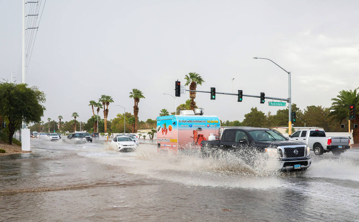 Cars battle rush hour traffic amidst flash flood along Eastern Avenue and Robindale Road on Fri ...