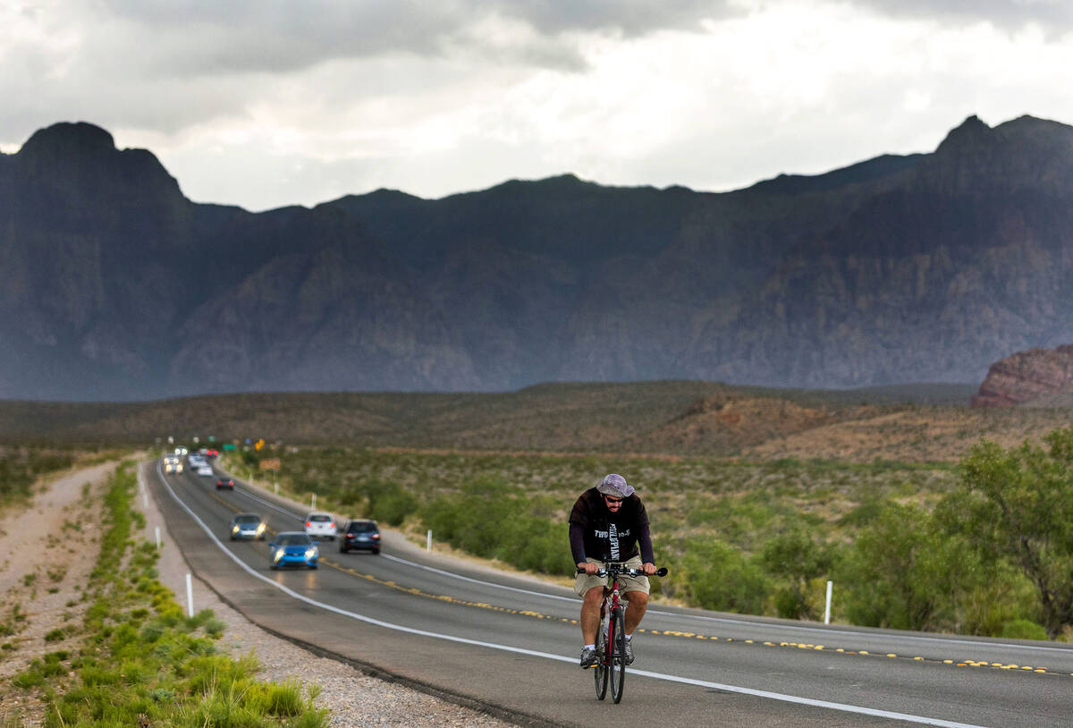 A cyclist pedals fast in an attempt to avoid a serious downpour headed through the Red Rock Can ...