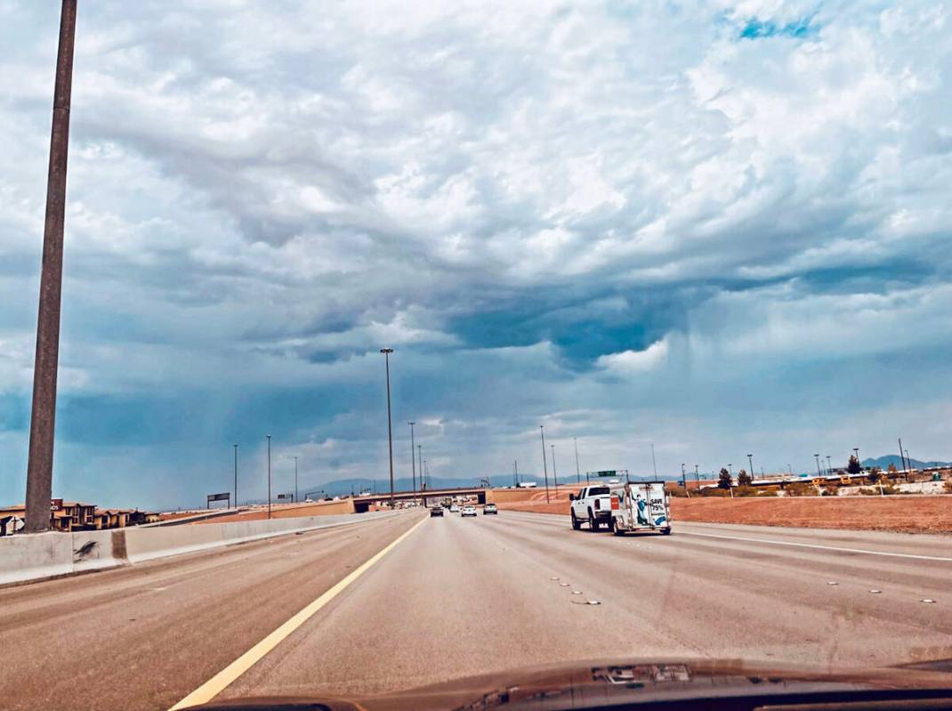 Heavy clouds over Las Vegas as a motorist heads north on Interstate 15 during the afternoon of ...
