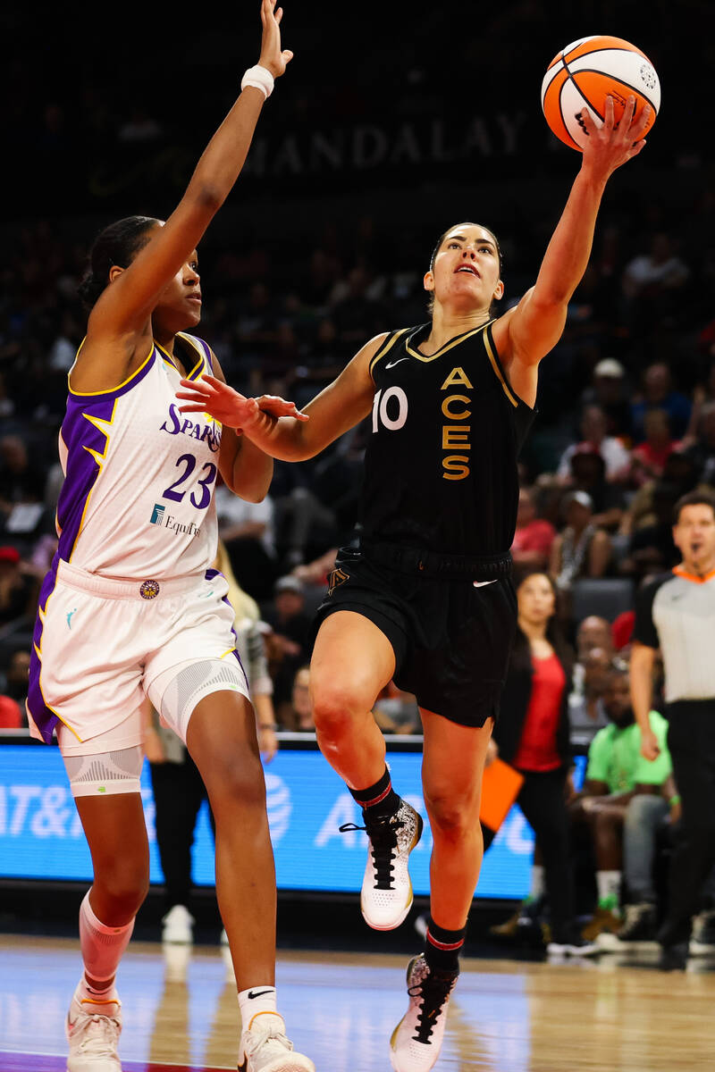Las Vegas Aces guard Kelsey Plum (10) goes in for a lay up around Los Angeles Sparks forward Az ...