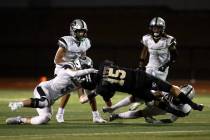 Faith Lutheran quarterback Alex Rogers (15) is tackled by Palo Verde players including Nathan K ...