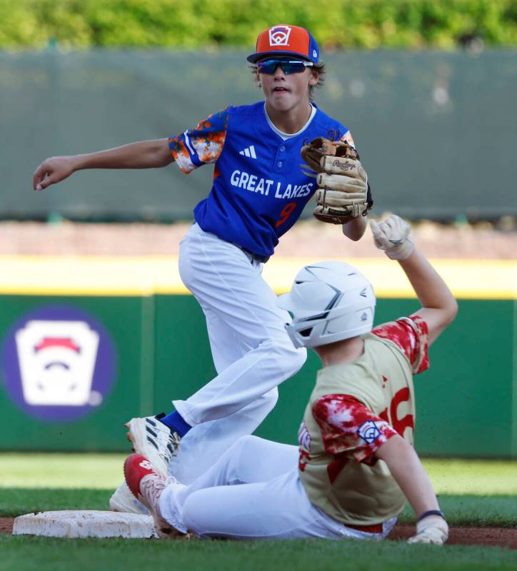 The Henderson All-Stars third baseman Logan Levasseur beats a throw and slides safe at second a ...